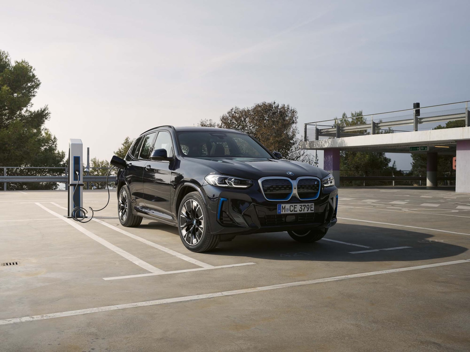 BMW iX3 laddar på en parkeringsplats