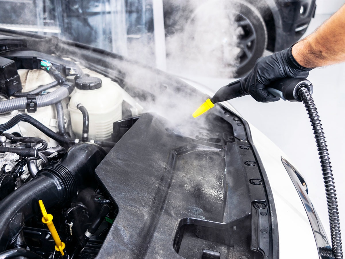 Serviceteknikern utför en motortvätt Serviceteknikern utför en motortvätt
